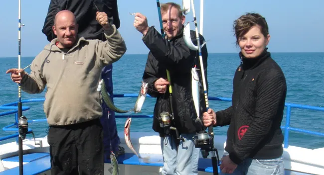 Pêcheur tenant un maquereau à bord de l'Aigue Marine